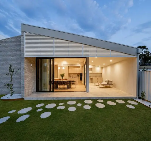 The rear opens to the lawn through full height sliding glass