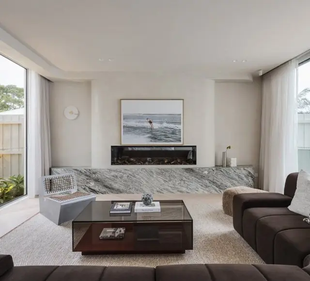 Living room with a stone clad fireplace and garden outlook
