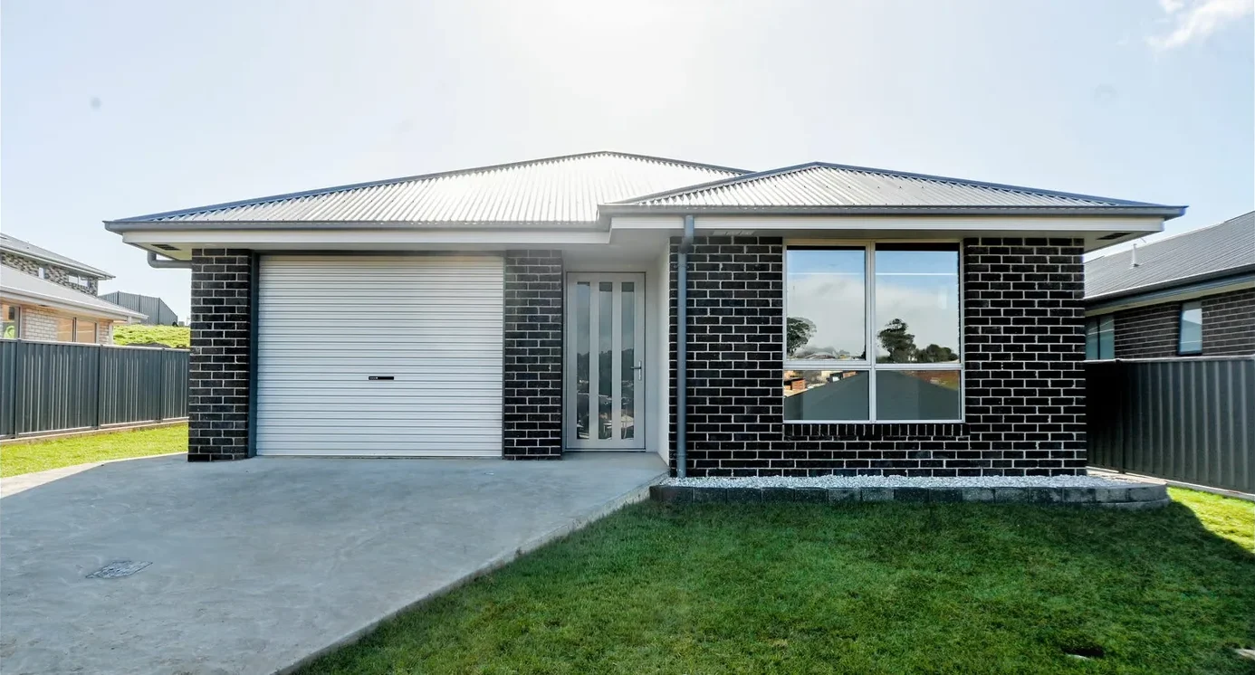 Brand new single storey charcoal brick home at 4 Larkin Court, Shorewell Park, Tasmania, with a concrete driveway, garage and newly laid lawn